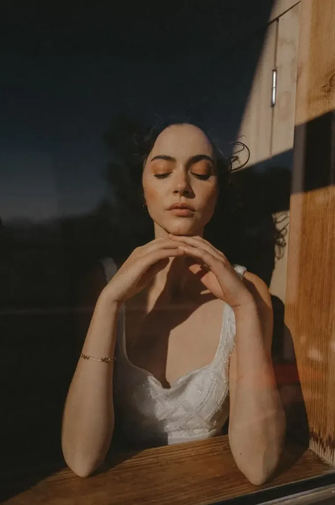 L'art de la guérison et de l'introspection Une femme regardant par une fenêtre, évoquant l'introspection et la guérison intérieure.
