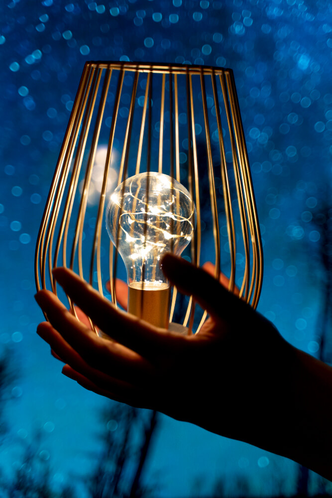 Une lampe ancienne illuminant l'obscurité, métaphore de la lumière intérieure trouvée dans l'ombre.